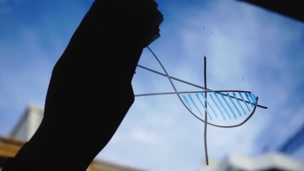 Estilo de vida: hermosa mujer joven limpiando gráficos de negocios de matemáticas del vidrio con cielo azul, rascacielos en el fondo. Silueta. Primer plano, de mano, cámara lenta 60 fps . — Vídeo de stock