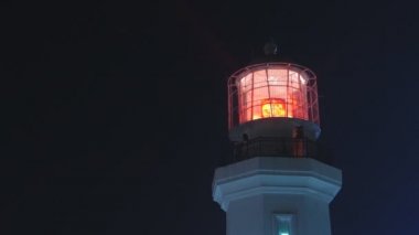 Kırmızı ışıkta gece, orta atış ile deniz feneri. Statik, yavaş hareket 60 fps.