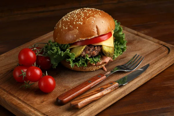 Hambúrguer Uma Mesa Madeira Escura Com Tomates Talheres — Fotografia de Stock