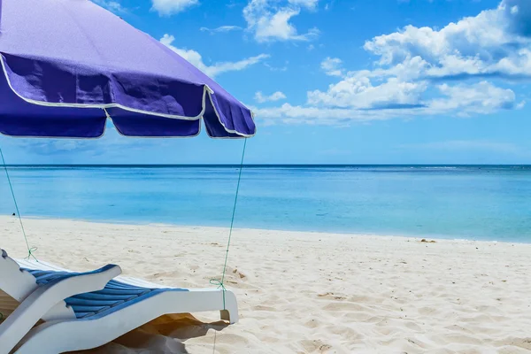 Guarda-chuva coberto cadeira de praia — Fotografia de Stock