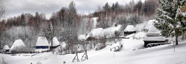 Kışın ahşap kulübeleri ve çitleri olan otantik Ukrayna köyü..