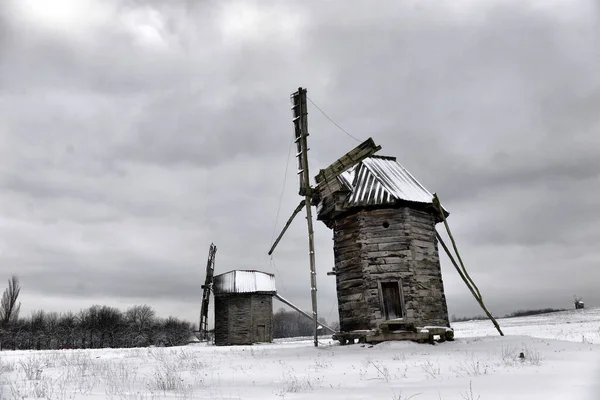 古老的木制风车在雪地的乌克兰村庄 冬季景观 免版税图库图片