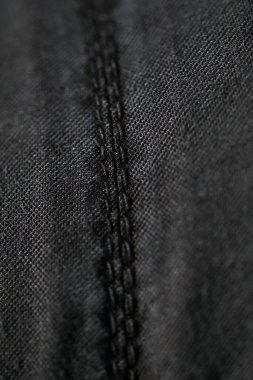 Koyu renk kumaş arkaplanda dikiş 