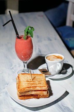 Sandviç, bir fincan kahve ve meyve suyu, kahvaltı. 