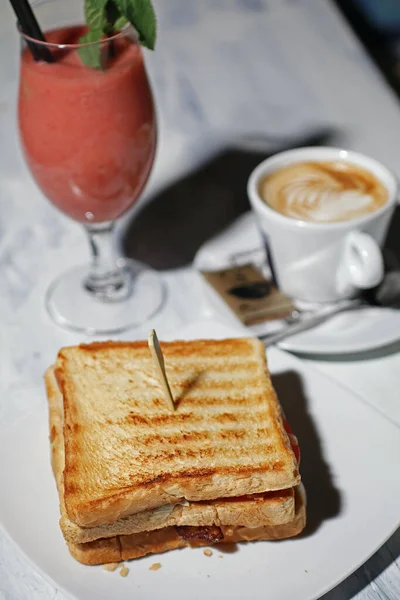 Sandwich with cup of coffee and fruit smoothie, breakfast