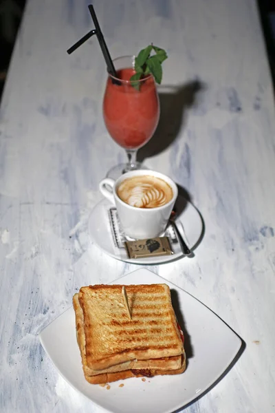 Sandwich with cup of coffee and fruit smoothie, breakfast