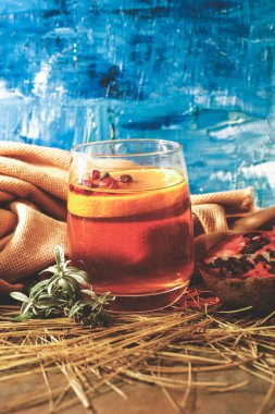 Baharatlı bir bardak şarap ve ahşap masada otlar.