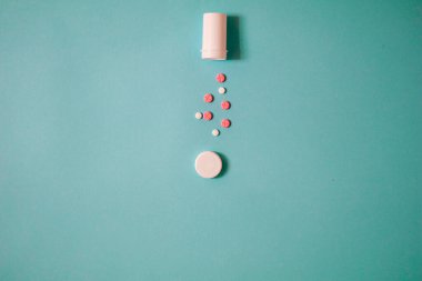 Mavi arkaplanda beyaz hap ve kapsül