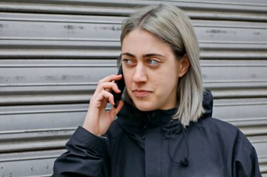 Akıllı telefon kullanan gümüş saçlı bir kızın portresi.
