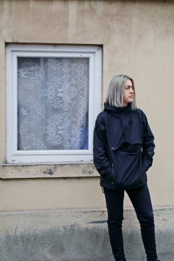 Pencereli, eski evin yakınında mavi elbiseli bir kız.