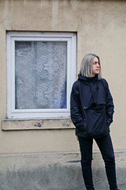 Pencereli, eski evin yakınında mavi elbiseli bir kız.