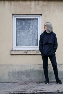 Pencereli, eski evin yakınında mavi elbiseli bir kız.