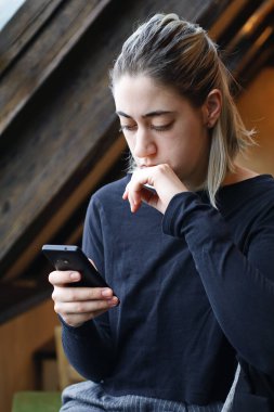 Akıllı telefon kullanan gümüş saçlı bir kızın portresi.