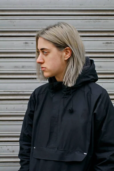 portrait of a girl with silver hair dressed in black on metal background