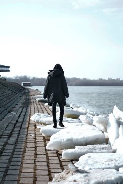 Genç yakışıklı adam nehir kenarında poz veriyor.