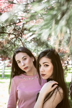 two ladies with makeup posing in park