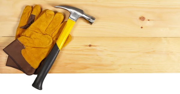 Llave de martillo y guantes sobre fondo de madera — Foto de Stock