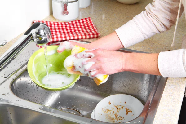 Mani lavare i piatti con acqua corrente dal rubinetto — Foto Stock