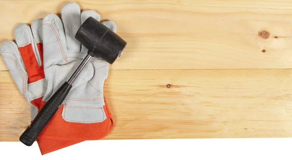 Llave de martillo y guantes sobre fondo de madera —  Fotos de Stock
