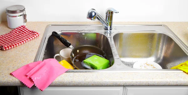 Hands washing dishes with running water from faucet — Stock Photo, Image