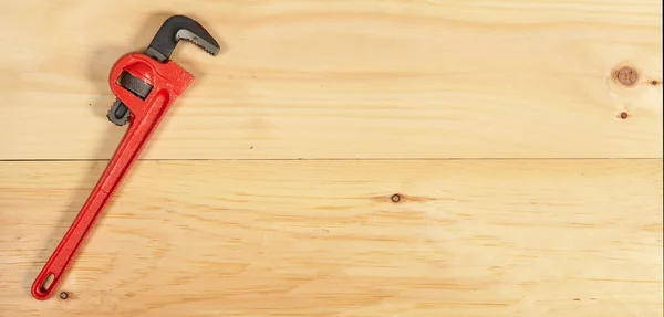 Ключ аллигатора на деревянном фоне — стоковое фото