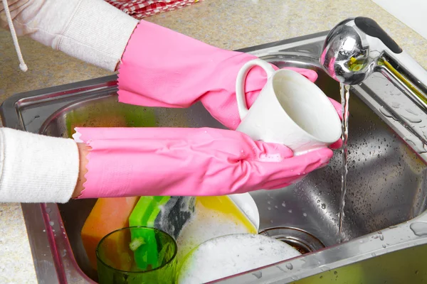 Mãos lavando pratos com água corrente da torneira — Fotografia de Stock