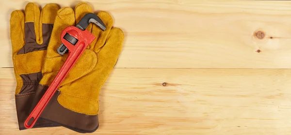 Llave y guantes llave inglesa sobre fondo de madera —  Fotos de Stock