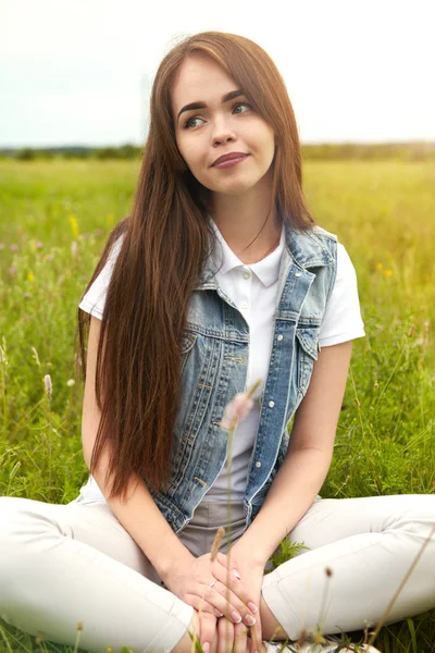 Vacker flicka i en äng på morgonen — Stockfoto