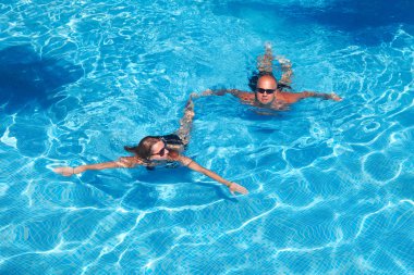 çift havuzda yüzüyor