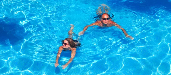 Paar schwimmt im Pool — Stockfoto