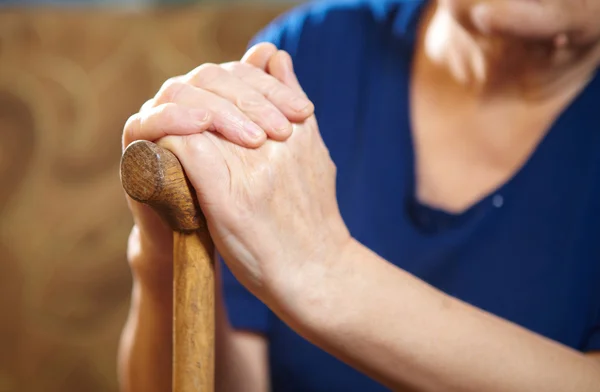 Vecchia donna mani con canna — Foto Stock