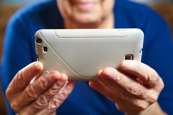 Пожилая женщина со смартфоном — стоковое фото