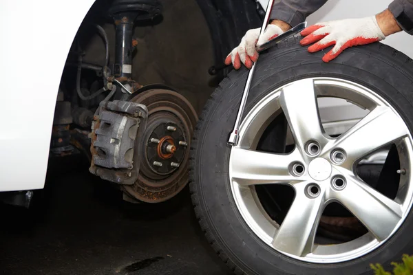 Car mechanic changing tire. — Stock Photo, Image