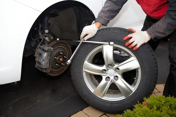 Car mechanic changing tire. — Stock Photo, Image