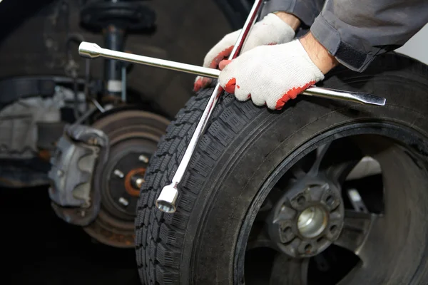 Car mechanic changing tire. — Stock Photo, Image