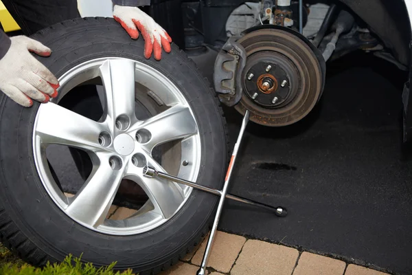 Car mechanic changing tire. — Stock Photo, Image