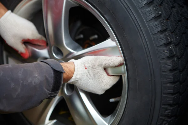 Car mechanic changing tire. — Stock Photo, Image