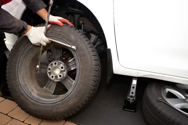 Car mechanic changing tire. — Stock Photo, Image