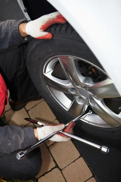 Car mechanic changing tire. — Stock Photo, Image