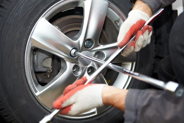 Car mechanic changing tire. — Stock Photo, Image