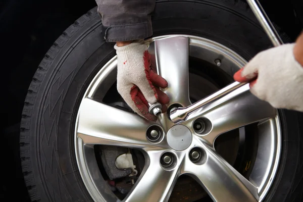 Car mechanic changing tire. — Stock Photo, Image