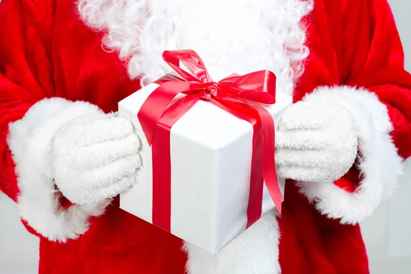 Mãos de Papai Noel com presente — Fotografia de Stock