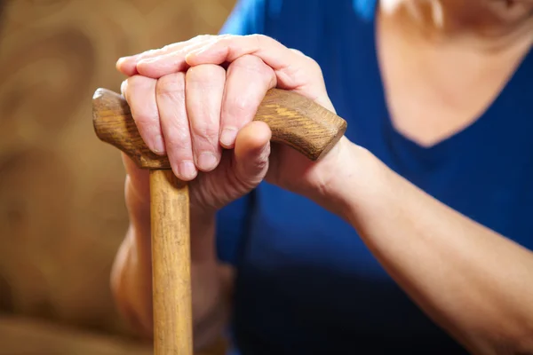 Vecchia donna mani con canna — Foto Stock