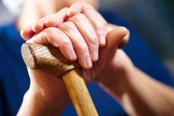 Oude vrouw handen met stok — Stockfoto