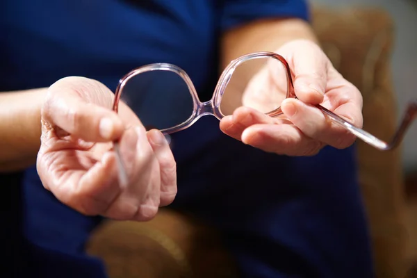 Old woman hands with eyeglasses — Stock Photo, Image