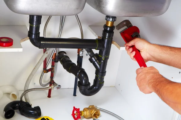 Plumber on the kitchen. — Stock Photo, Image