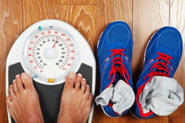A pair of man's feet standing on a scale — Stock Photo, Image