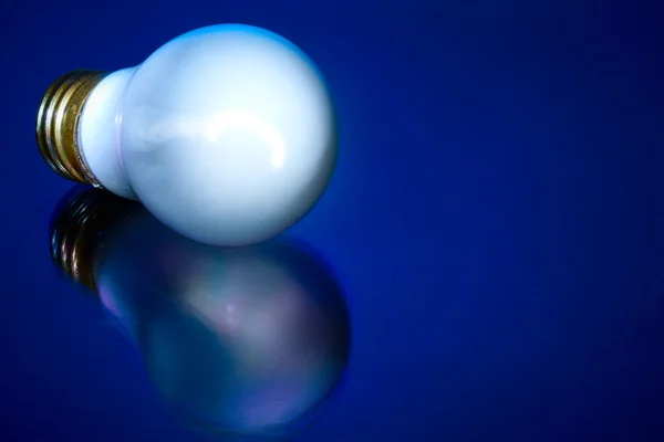 Glödlampa på blå bakgrund — Stockfoto