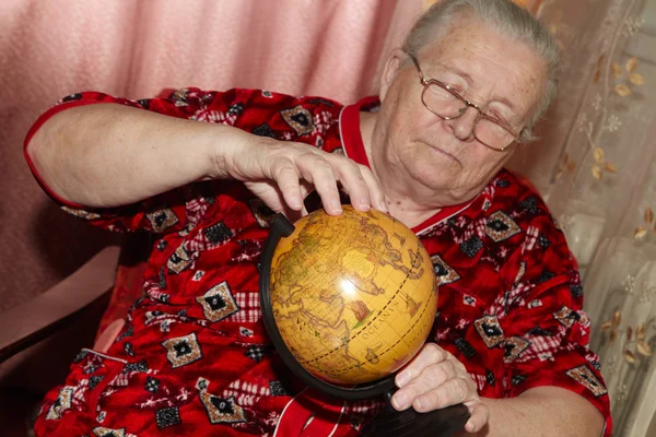 Mulher idosa e globo terrestre — Fotografia de Stock