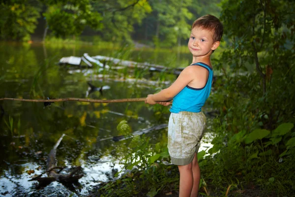 Liten pojke fiske i en flod — Stockfoto